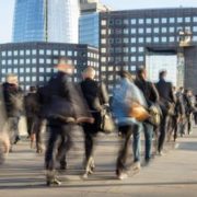 Blurred image of business commuters crossing London Bridge, office buildings with The Shard are visible in the background, London, England