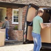 Family Unloading Boxes From Removal Truck On Moving Day