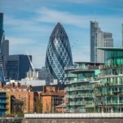 London, England -  25 March 2017 : The Gherkin building and other commercial and residential properties in London as seen from the river Thames, UK